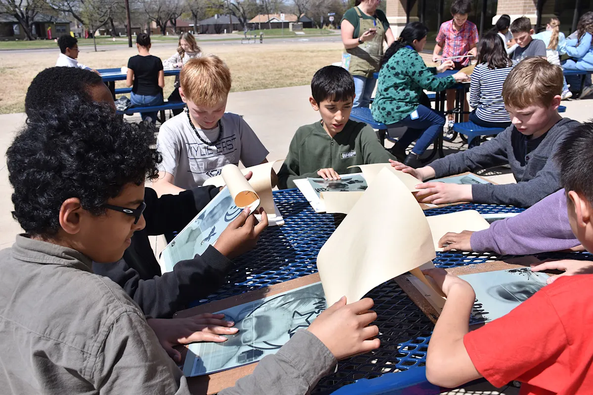Harrison students working on their solar science art at an outdoor table.