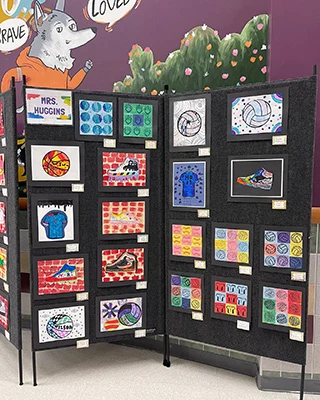 A photo of display screens containing the Veterans Day art made by Whitt students.